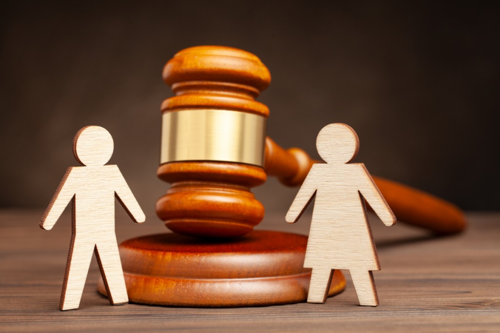 Bonecos de papel representando casal na frente de martelo de juiz - partilha de bens com usufruto