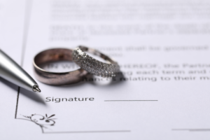 Contrato de casamento com par de alianças prata e caneta - Regime de bens casamento alteração