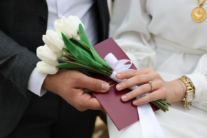 casal segura flores em trajes de casamento - regime de bens casamento civil